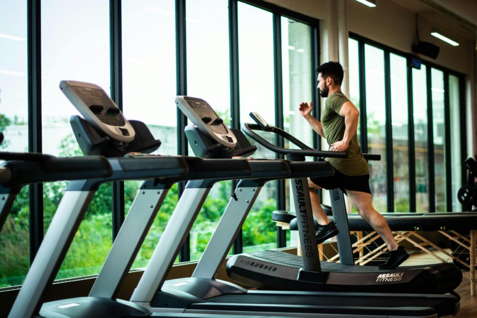 Uomo che corre sul tapis roulant in palestra per un articolo sul treadmill workout